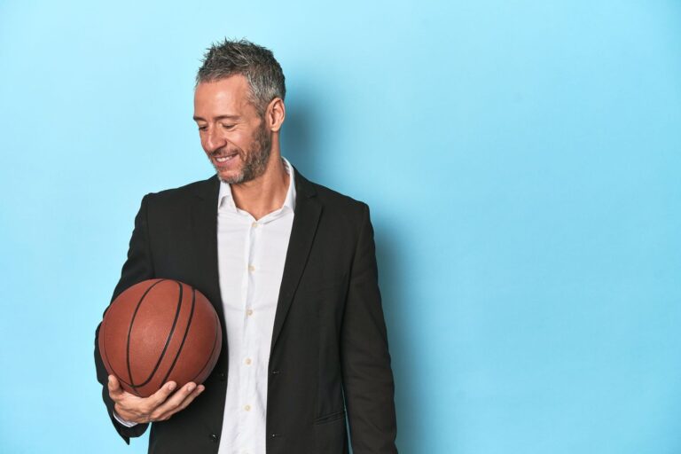 Homme en chemise et veste qui tient un ballon de basket