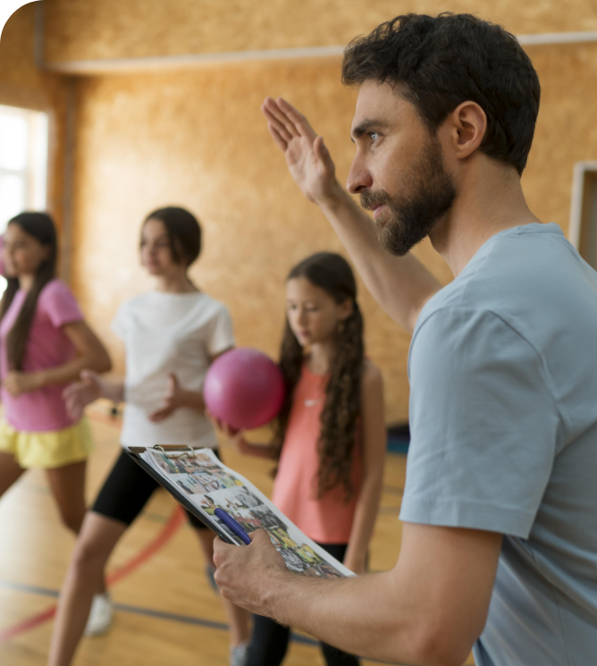 professeur de sport donnant des consignes à des jeune filles en tenue de sport