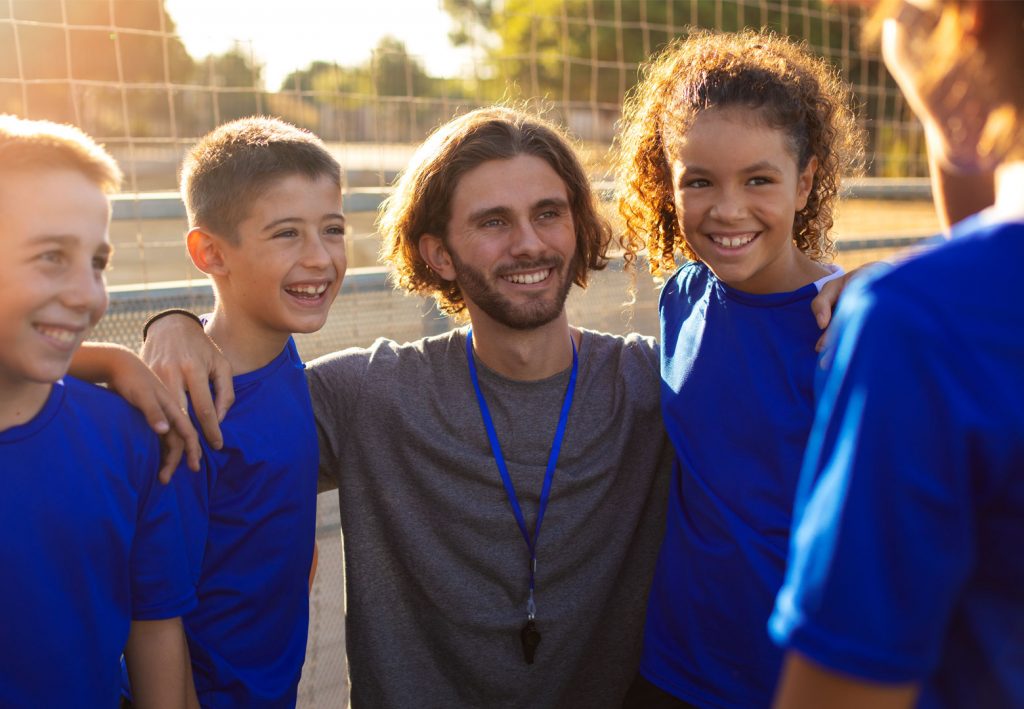 enfants souriants avec leur entraineur